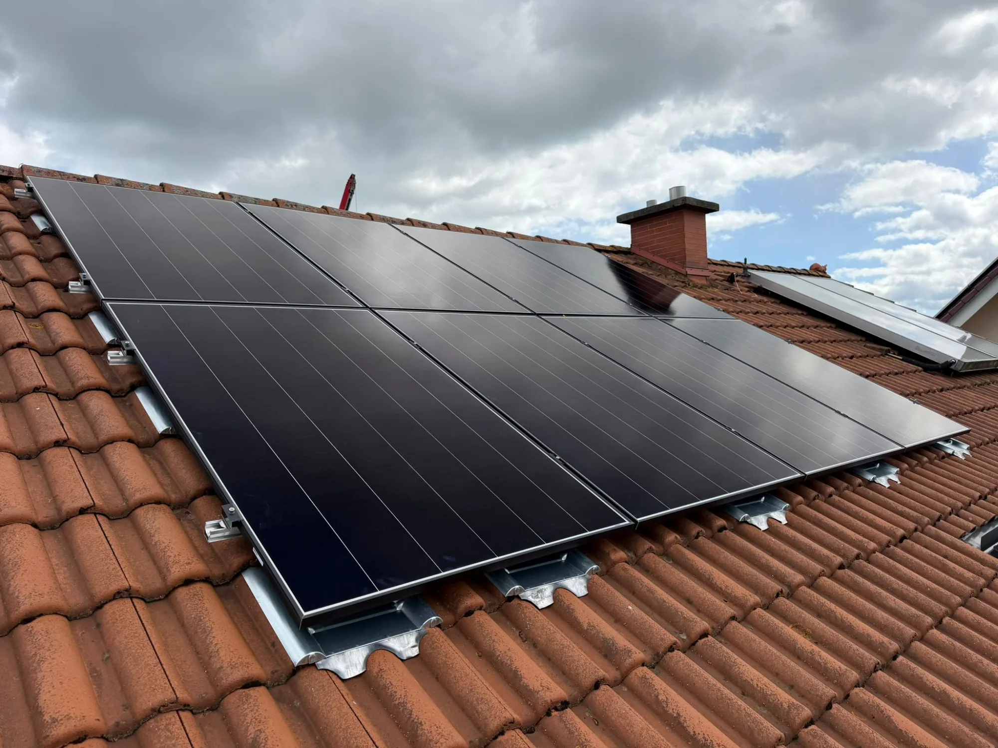 Photovoltaik-Module montiert auf einem roten Ziegeldach.