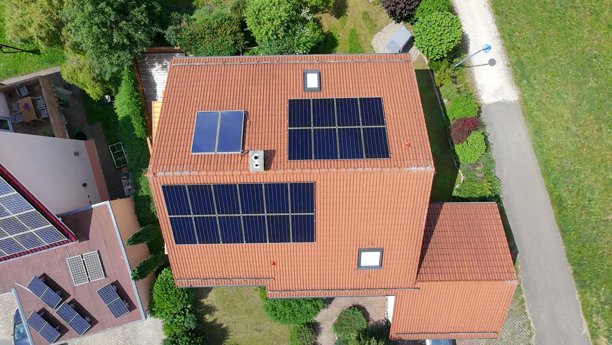 Luftaufnahme eines Einfamilienhauses mit Photovoltaikmodulen auf dem Ziegeldach